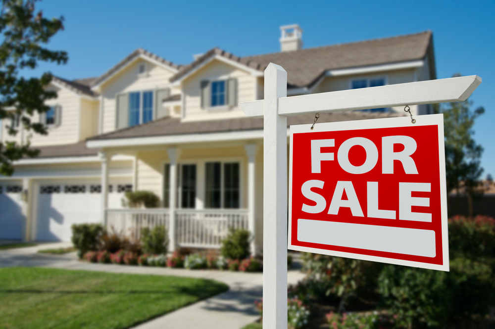 home for sale real estate sign in front of new house.